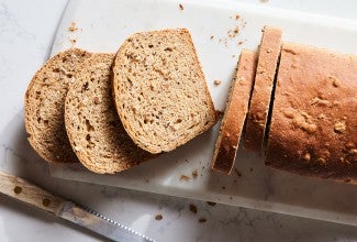 A loaf of malted wheat bread cut into slices